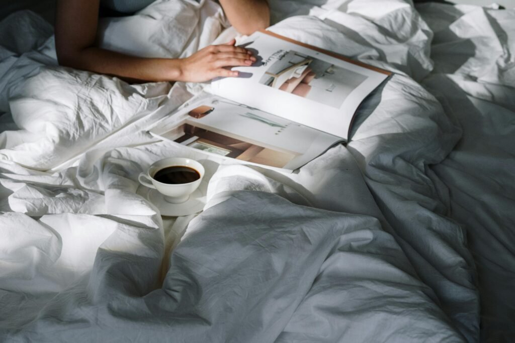 Refined Japan - a woman reading an aesthetic magazine on the bed with coffee