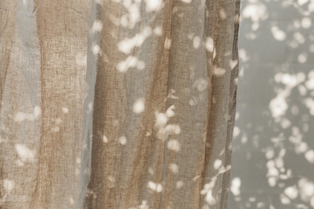 a curtain with a shadow of leaves